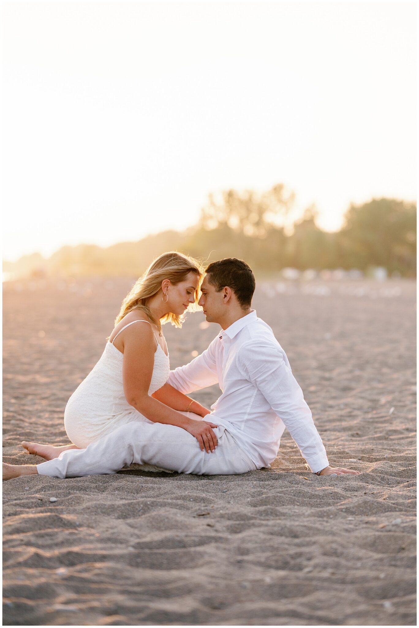 Couple sitting facing each other on Erieau beach at sunset Lake Erie